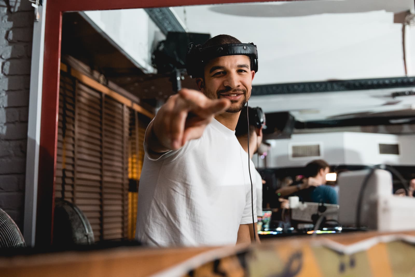 Austin Ventour smiling and pointing at the camera from the DJ booth