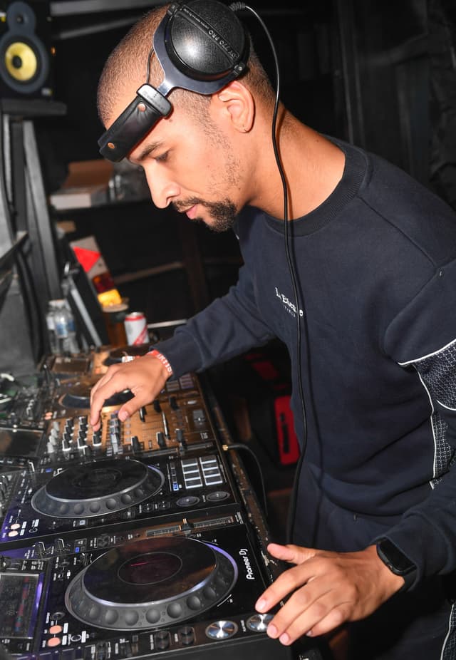 Austin Ventour cueing a record on club decks with one headphone cup pushed up