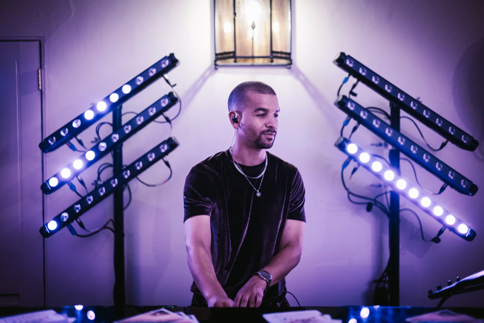 Austin Ventour at the decks in a velvet T-shirt, between two stands of blue-white LED bars