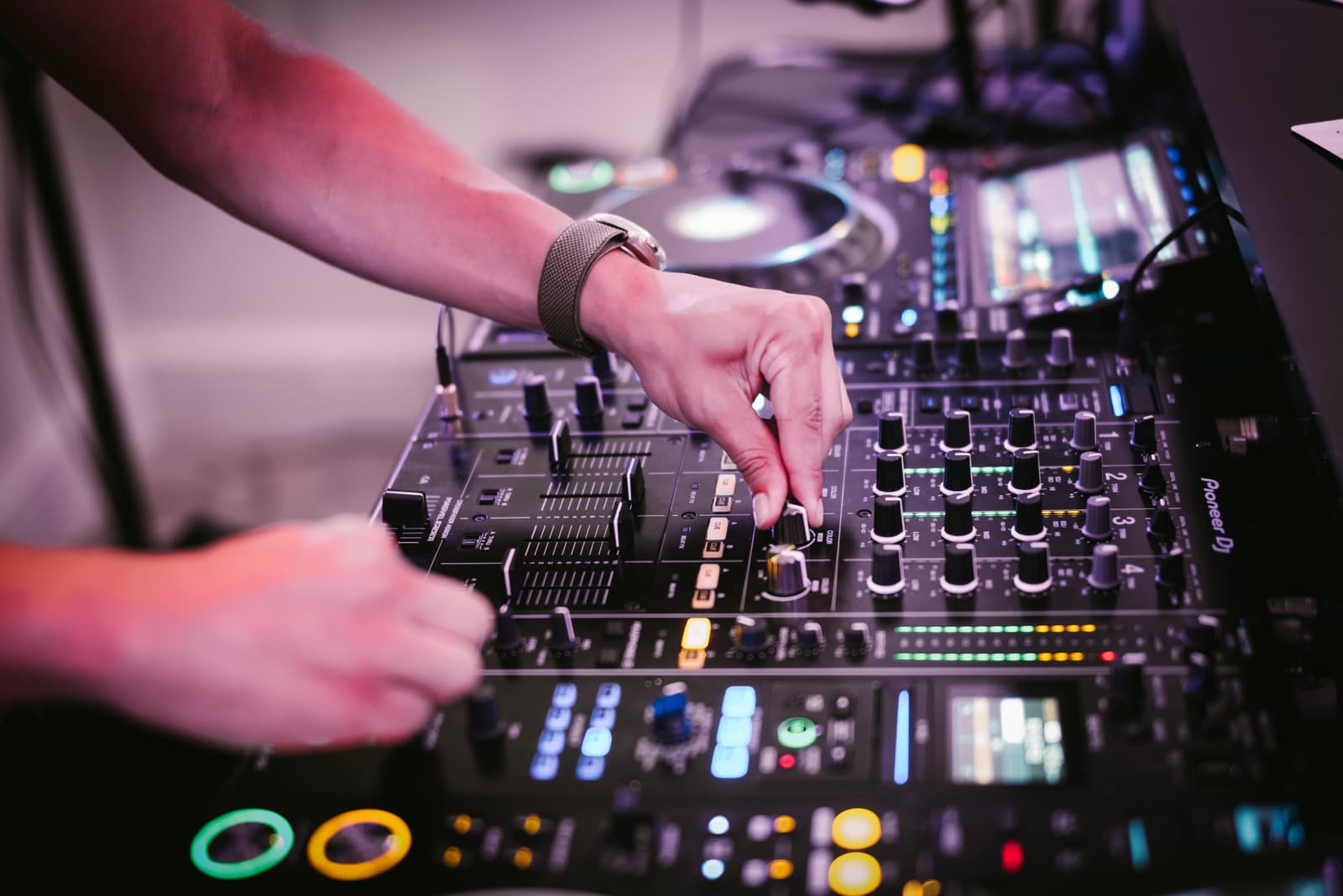 Close-up of Austin Ventour&rsquo;s hands on a Pioneer mixer, one turning an EQ knob