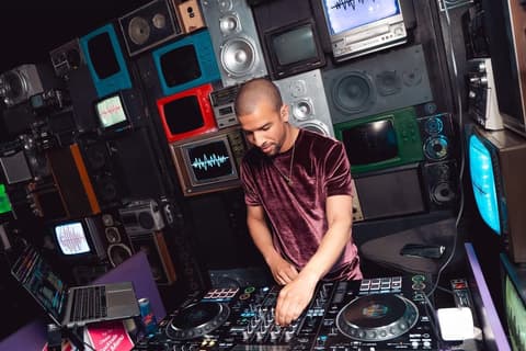 Austin Ventour mixing in front of a wall of vintage speakers and old television sets